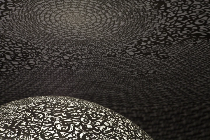 Interior view inside the openwork globe looking up, the perforated dome casting patterned light, Globe N°1.