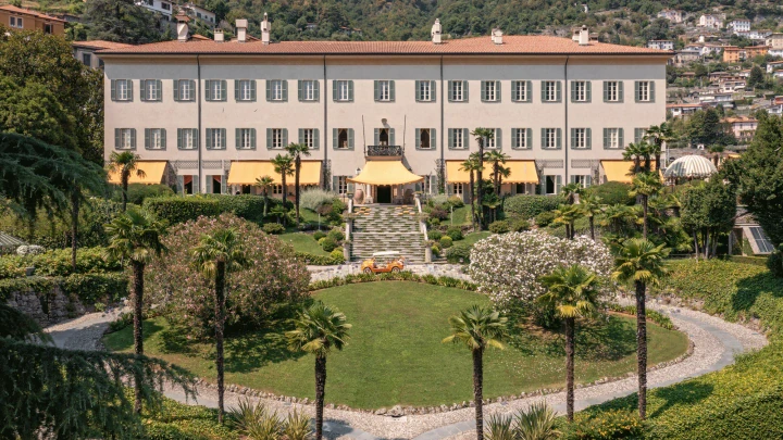 Aerial view of a grand Italian villa with terraced gardens and a central fountain.