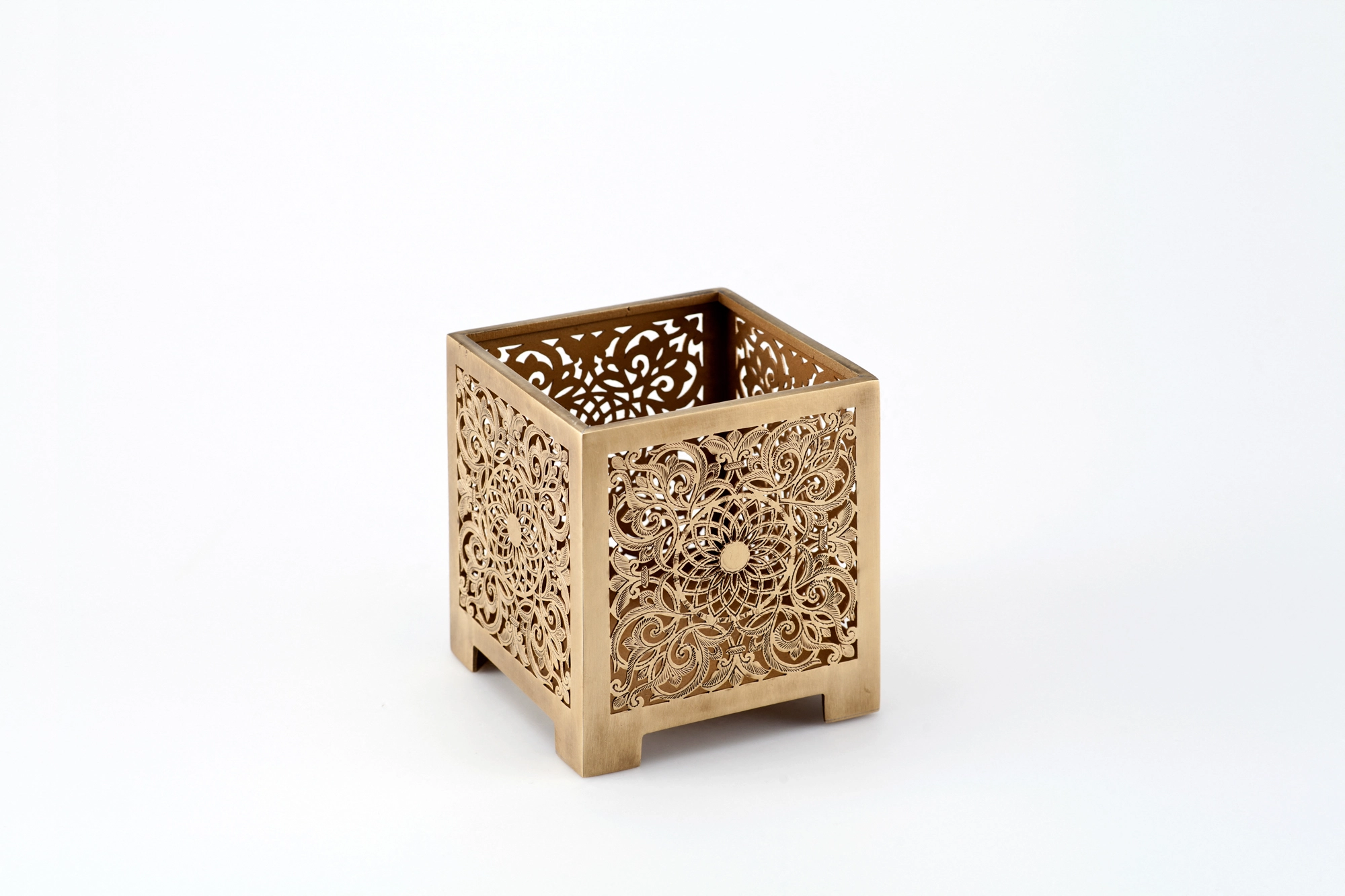 A square pierced metal candle box in a warm brass finish, photographed unlit against a white background.