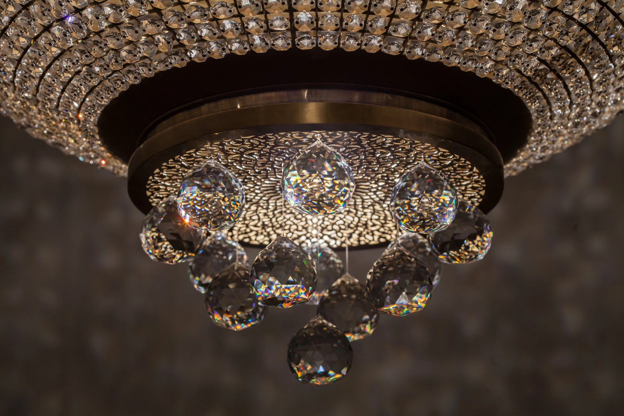 A crystal chandelier seen from below, with beaded tiers and small pierced globes around its base.