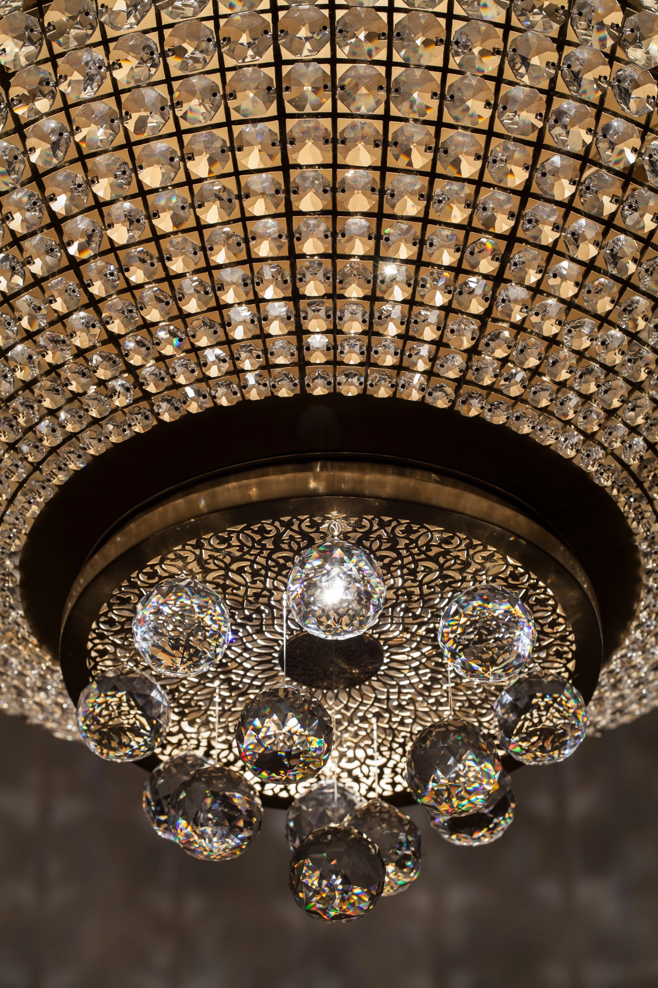 Close-up of a crystal chandelier's lower beaded tiers and faceted glass globes.