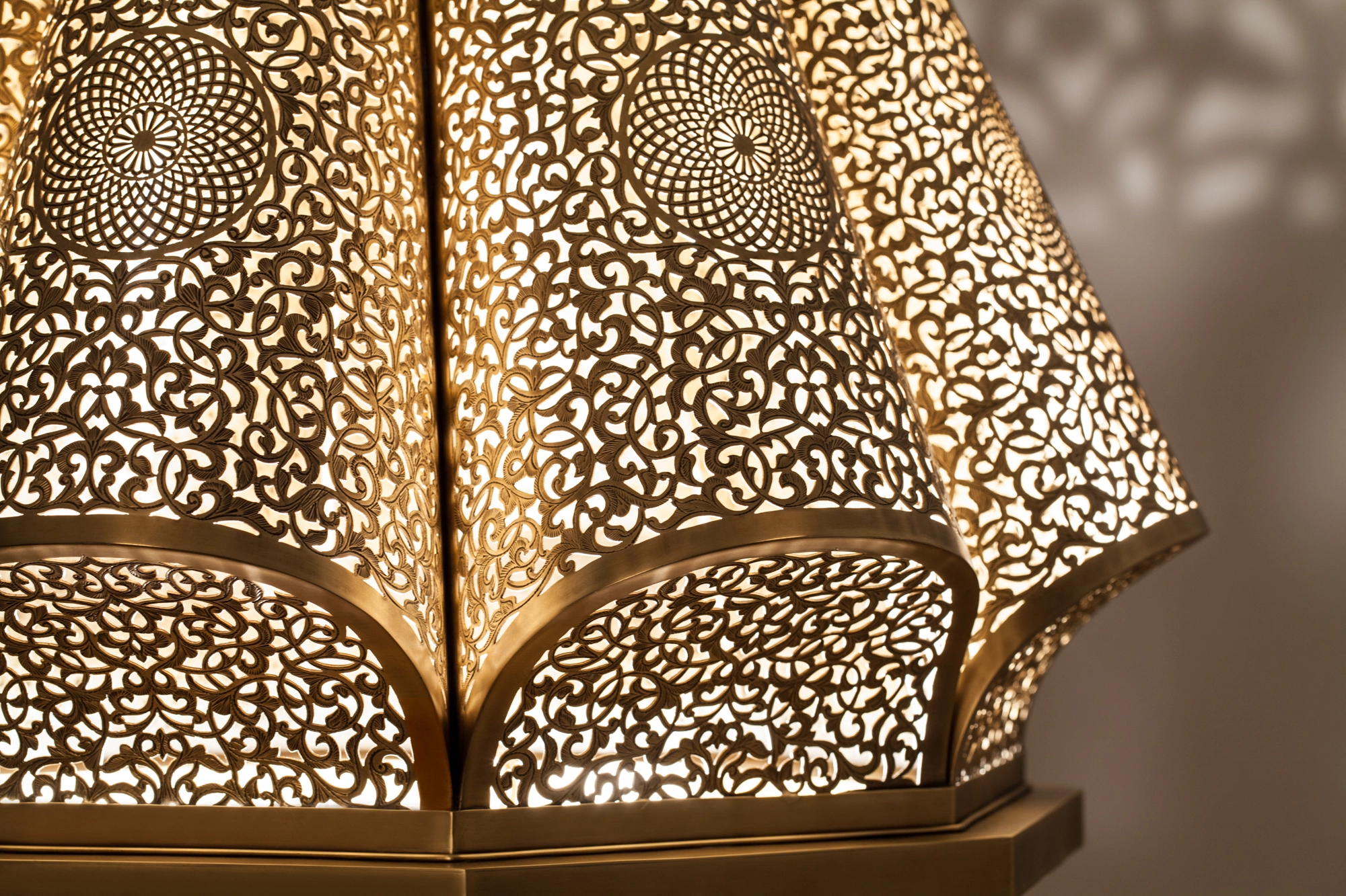 Close-up of a pierced lantern pendant's domed top scattering a fine spray of dotted light.