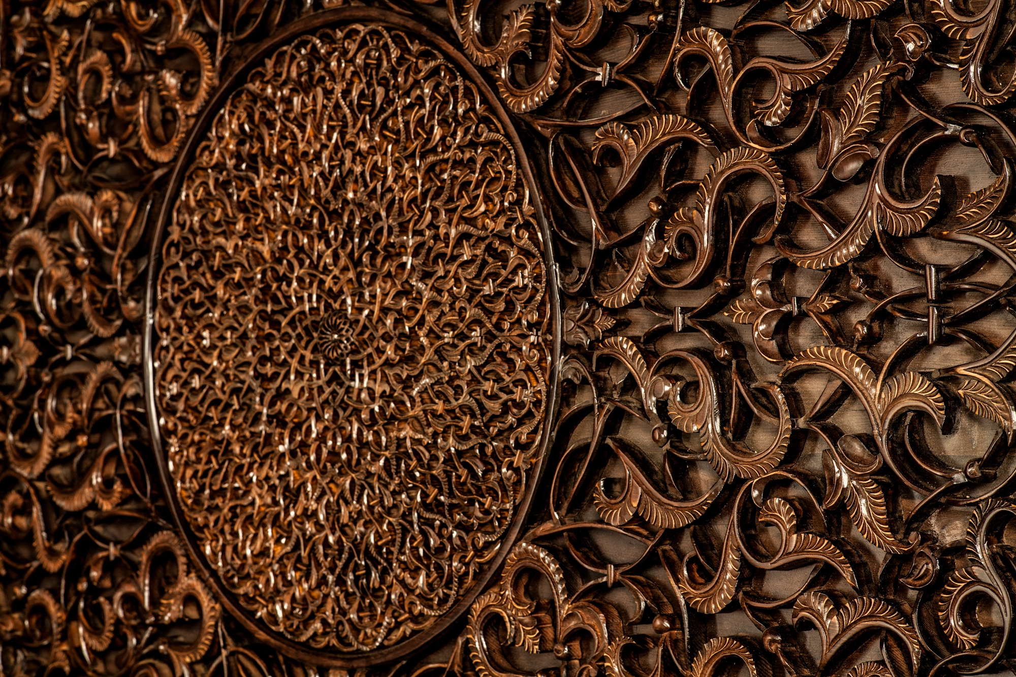 Carved dark-wood foliage openwork surrounding an inset oval central medallion.