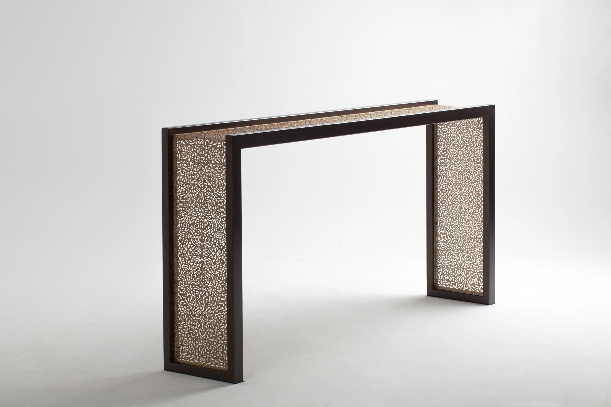 A console table with pierced metal side panels in a dark frame, seen at an angle against a white background.