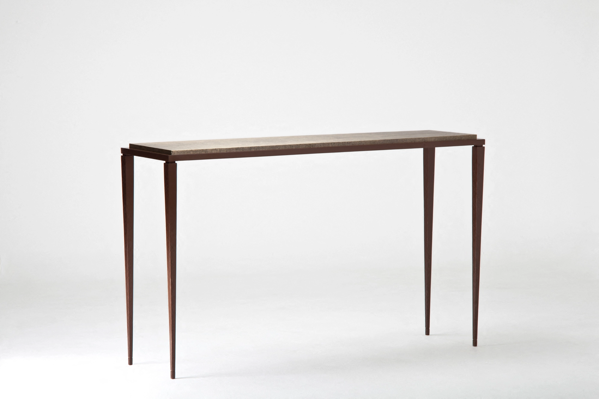 A slim minimal console table with a thin top and tapered legs, photographed against a white background.