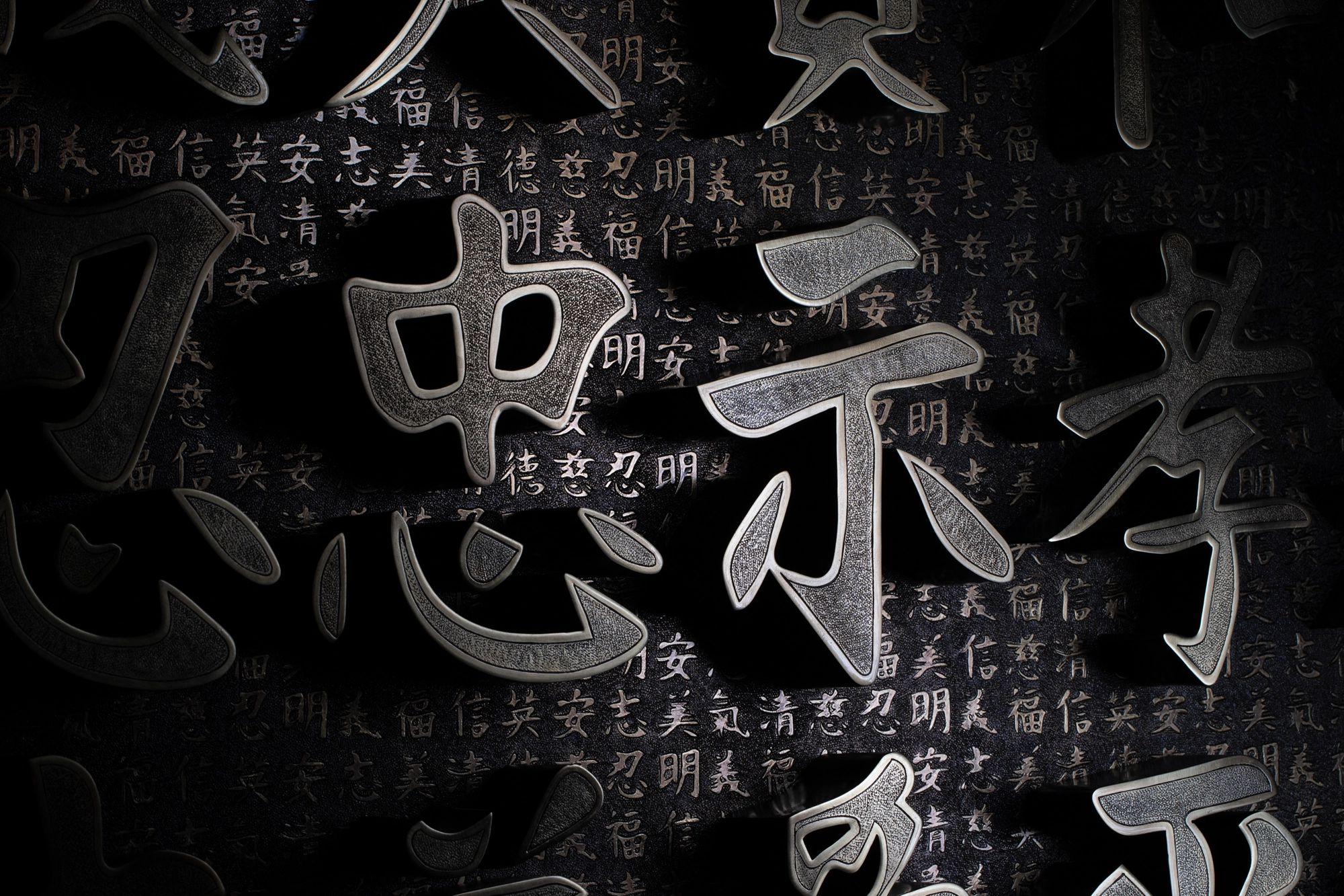 Tight close-up of raised metallic Chinese characters on a black ground, 36 Chambers 818 series.